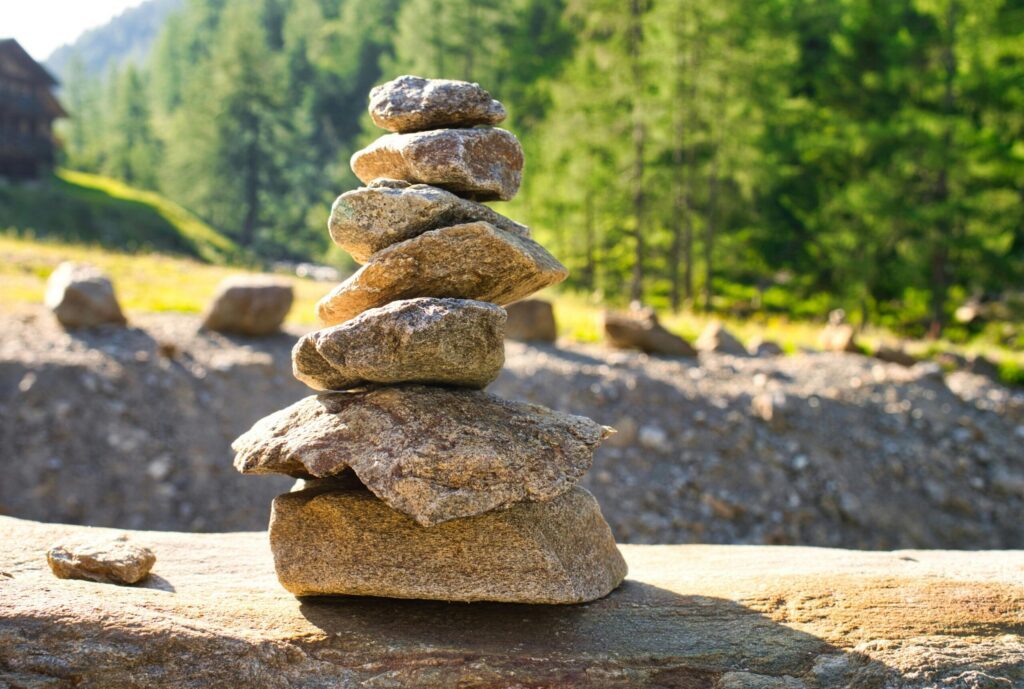 A serene arrangement of stacked stones with a blurred forest backdrop, capturing nature's balance.